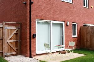 a patio with a door and two chairs and a table at Gadslodge in Birmingham