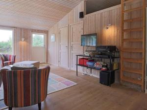 a living room with wood paneled walls and a television at 6 person holiday home in Slagelse in Slagelse