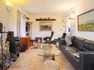 uma sala de estar com um sofá de couro e uma mesa de vidro em 6 person holiday home in G rlev em Gørlev