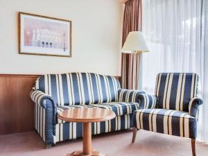 um quarto de hotel com duas cadeiras, um sofá e uma mesa em Apartment on the lakeside in Hahnenklee em Hahnenklee-Bockswiese