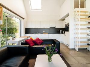 Holiday home Viroinval في Petigny: غرفة معيشة مع أريكة سوداء ومطبخ