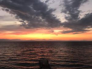 a boat in the ocean with a sunset at Eros Beach Hotel in Benitses