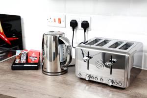 a toaster and coffee maker on a kitchen counter at Gadslodge in Birmingham