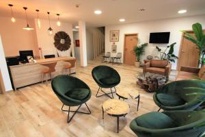 a living room with green chairs and a desk at Hotel Frýdl in Prague