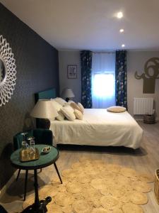 Un dormitorio con una gran cama blanca y una mesa en Cloutiers26 en La Rochelle
