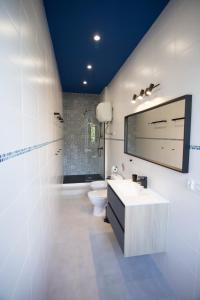 a white bathroom with a sink and a toilet at Luxurio rooms with baths in Livorno