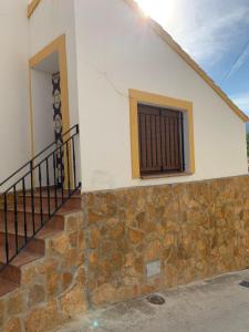 une maison avec un mur en pierre et une fenêtre dans l'établissement Habitación Rural El Chorrillo, à Castril