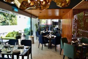 a restaurant with tables and chairs in a room at Casa Prim Hotel Boutique in Mexico City