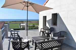 a patio with a table and chairs and an umbrella at ¡Nuevo! Casa reformada, cómoda y con vistas al mar in Santander