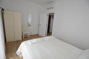a white room with a bed and a chair at Lagos Central Apartments Ap 1 in Lagos