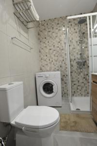 a bathroom with a toilet and a shower and a washing machine at Lagos Central Apartments Ap 1 in Lagos