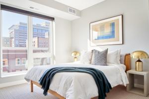 a white bedroom with a bed and a large window at Sonder at Vicinity in Minneapolis