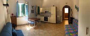 a living room with a blue couch and a kitchen at Liana monolocale in San Vincenzo
