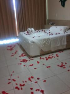 um quarto com pétalas de rosa vermelhas no chão em Ocean View Hotel em Arraial do Cabo