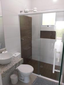 a bathroom with a toilet and a glass shower at Moriá Flats in Ubatuba +54 photos