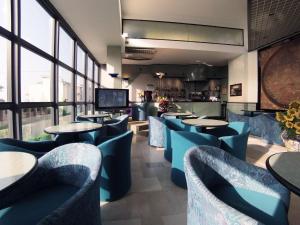 a restaurant with tables and chairs and a bar at Hotel Acropolis in Cattolica