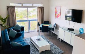 a living room with a couch and a table at Waiheke Island Motel in Ostend