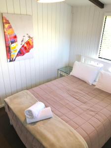 a bedroom with two beds with towels and a painting at Waiheke Island Motel in Ostend