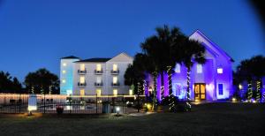 a large white building with christmas lights in front of it at 30-A Inn & Suites in Santa Rosa Beach