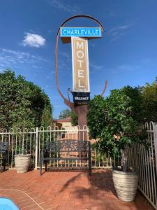 a sign in front of a fence with a bench at Charleville Motel in Charleville