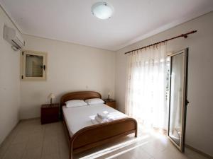 a bedroom with a bed and a large window at Manoleas Villas - Apartment 2 in Stoupa +49 photos