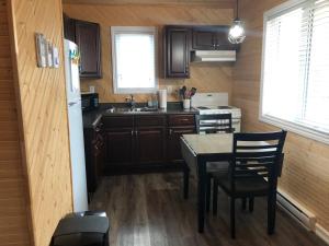 a kitchen with a table and chairs and a sink at The Southern Port Hotel & Chalets in Harbour Breton