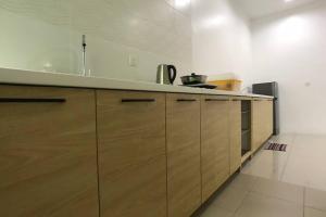 a kitchen with wooden cabinets and a counter top at be.Animania -8-10mins Lost World Tambun -14-18pax in Ipoh