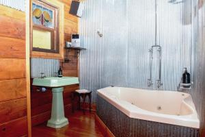 un baño con bañera y lavabo en Colby Cottages, Wooragee near Beechworth, en Wooragee 36 fotos más