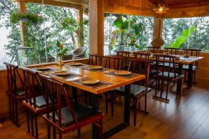 a restaurant with wooden tables and chairs and windows at Tubotel Sapa in Sa Pa