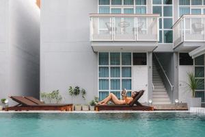 a woman laying on a chair next to a swimming pool at PaiApartHotel in Pai