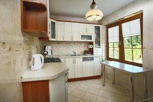 a kitchen with white cabinets and a counter top at Dom w Lubiatowie in Lubiatowo