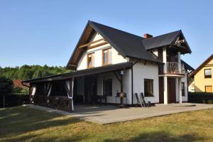 ein großes weißes Haus mit einem schwarzen Dach in der Unterkunft Dom w Lubiatowie całoroczny in Lubiatowo