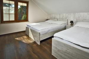 zwei Betten in einem weißen Zimmer mit Fenster in der Unterkunft Dom w Lubiatowie całoroczny in Lubiatowo