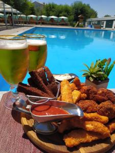 un plato de comida y dos vasos de cerveza en Hotel Victoria, en Kapchagay