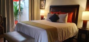 a hotel room with a large bed with orange pillows at Humuya Inn in Tegucigalpa