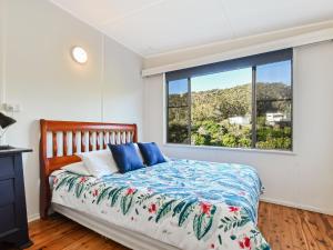 a bedroom with a bed and a large window at Briesta in Seal Rocks