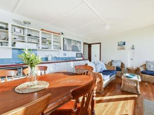 a kitchen and living room with a wooden table and chairs at Briesta in Seal Rocks