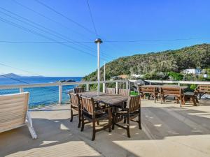 a table and chairs on a balcony overlooking the water at Briesta in Seal Rocks