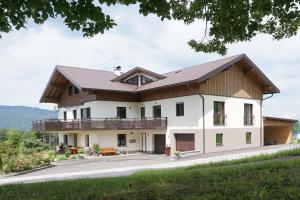 Casa blanca grande con techo de madera en Ferienwohnung Hausleitner, en Zell am Moos