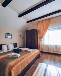 a bedroom with a large bed and a large window at Bucuria Muntelui in Bran +41 photos