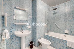アヴィニョンにあるホテル ダングルテールの青いタイル張りのバスルーム(洗面台、トイレ付)