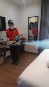 a man in a room holding a pizza box at Hotel JSL in Johor Bahru