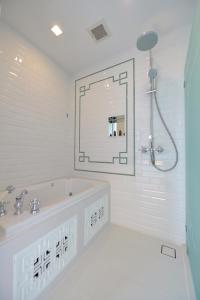 a bathroom with a shower, sink, and mirror at Riva Arun Bangkok - SHA Extra Plus in Bangkok