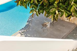 an overhead view of a pool with a table and chairs at Anemomylos Residence in Naousa