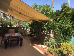a table and chairs under an umbrella on a patio at 439 HOUSE in Marina di Ragusa