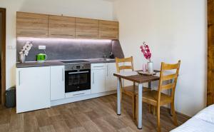 a small kitchen with a table and a stove at Apartmány Kurojedy in Bor
