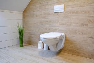 łazienka z toaletą i drewnianą ścianą w obiekcie Apartmány Kurojedy w mieście Bor +15 zdjęć