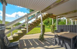 un patio con una escalera de madera y una mesa en Stunning Apartment In Væggerløse With Wifi And 1 Bedrooms, en Bøtø By