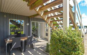 un patio con pérgola de madera, mesa y sillas en Stunning Apartment In Væggerløse With Wifi And 1 Bedrooms, en Bøtø By