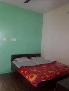 1 dormitorio con 1 cama con edredón rojo en Hotel Utsav Palace en Uttarkāshi